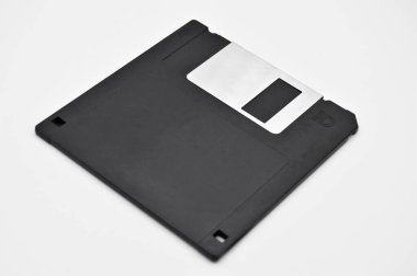 Eski bilgisayar ve veri depolama teknolojisi, siyah plastik manyetik disk 3.5 inç, beyaz arka planda izole edilmiş.