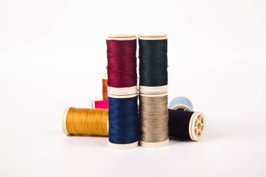 Farklı renklerde dikmek için iplik makaraları ve bobinleri, beyaz arka planda izole edilmiş.