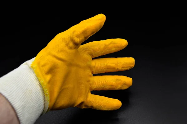 New and yellow protective work gloves isolated on black background