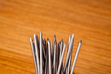 Metal demir çiviler çam ağacına çivi çakar, ahşap arka planda izole olur.