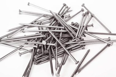 Bir sürü inşaat demir çivisi, endüstriyel parçalar, beyaz arka planda izole edilmiş.