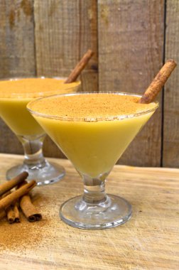 Boza ve tarçın çubukları, geleneksel Türk mutfağı içecekleri, ahşap bambu arka planda.