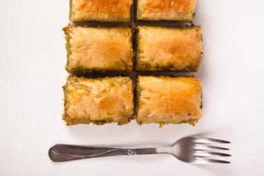 Baklava with pistachio, one of the most beautiful desserts of Turkish cuisine and metal fork knife. Turkish dessert baklava