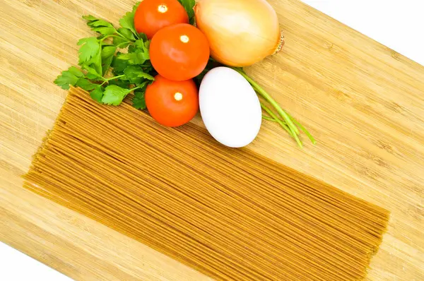 竹子切菜板上生食健康通心粉干面糊和有机西红柿 鸡蛋和洋葱 — 图库照片