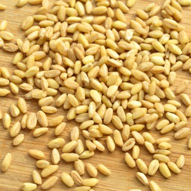 Bambu kesme tahtasının üzerinde bir sürü kuru buğday var.