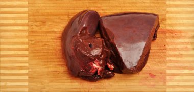 Keskin bıçak ve kesme tahtasında taze ve sağlıklı inek ciğeri.