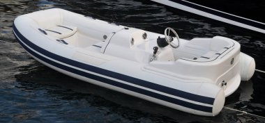 Deniz kenarında motoru olan modern şişirilebilir tekne, beyaz şişirilebilir tekne.