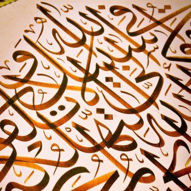 El yapımı kaligrafi kalemi ve İslam sanatı ile kağıt üzerinde İslam kaligrafi karakterleri