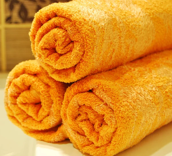 Three Orange Rolled Towels Ceramic Sink Luxurious Clean Bathroom — Stock Photo, Image