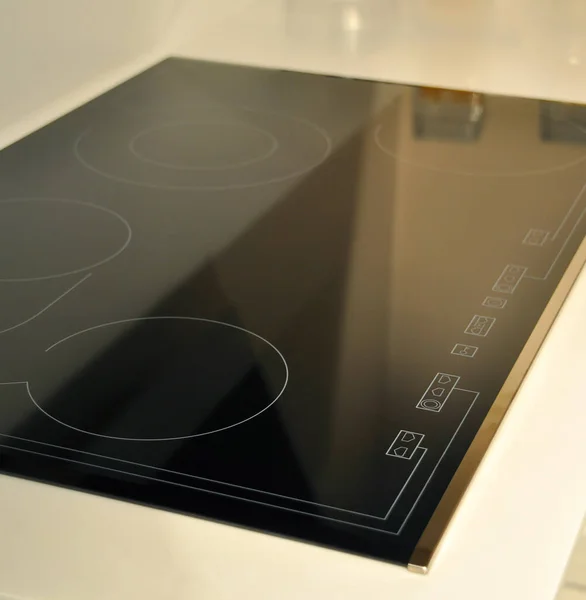 現代のクリーンキッチンとブラックガラスセラミック内蔵電気オーブンの詳細 — ストック写真