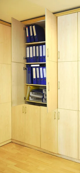 Blue and yellow files in a wooden cabinet in the modern office, office lifestyle