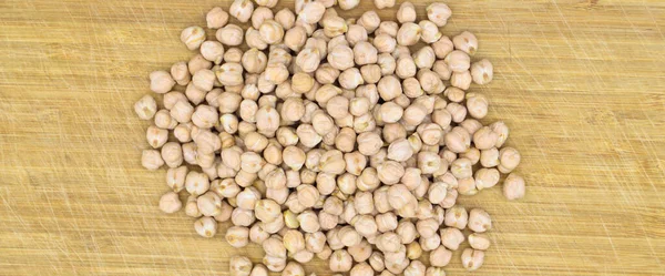 非常に栄養価が高く 木の背景に隔離された新鮮な乾燥したひよこ豆のヒープ — ストック写真