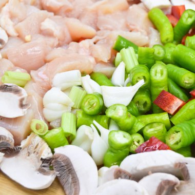 Organik taze biberli soğan mantarı çiğ tavuk eti, bambu kesme tahtasındaki çeşitli kesilmiş sebzeler.