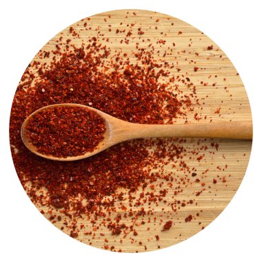 Bambu kesme tahtasındaki ahşap kaşıkta kurutulmuş kırmızı biber.