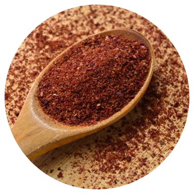 Tahta kaşık içinde bambu kesme tahtasının üzerinde organik aromalı sumak dokusu.