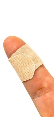 Yaralı bir başparmakla sarılmış bej bantlı kumaş.