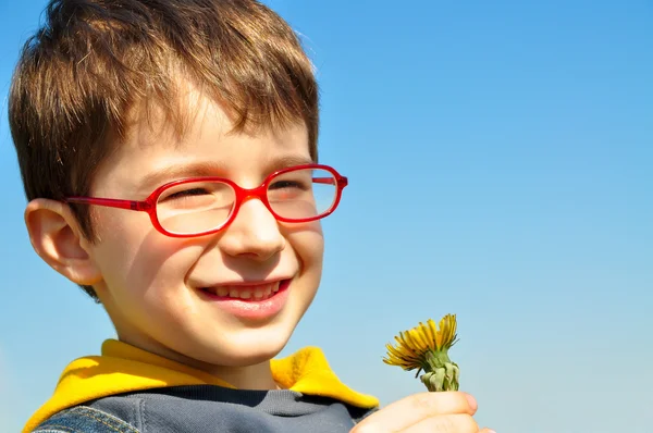 Niño soplando diente de león — Foto de Stock