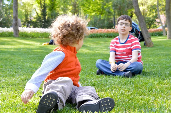 Two brothers playing in the grass — Stock Photo, Image