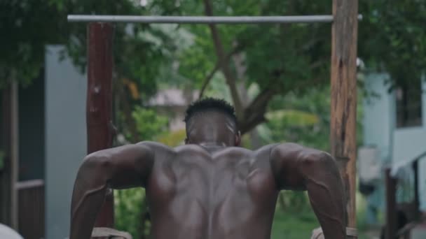Jeune homme en forme afro-américain faisant trempettes sur des barres parallèles — Video