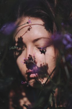 Çayırlık çiçeklerle çevrili güzel kadın yüzü