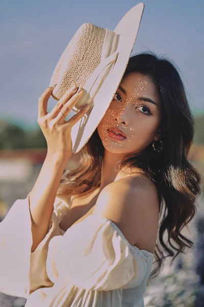 Estilo de vida retrato de moda de mujer asiática joven con estilo con sombrero de paja posando al aire libre —  Fotos de Stock