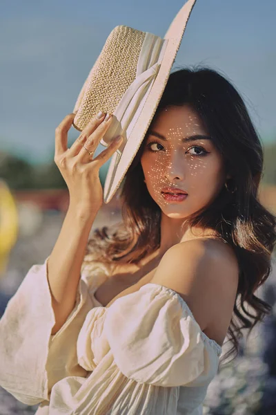 Lifestyle fashion portrait of stylish young asian woman with straw hat posing outdoor — Stock Photo, Image