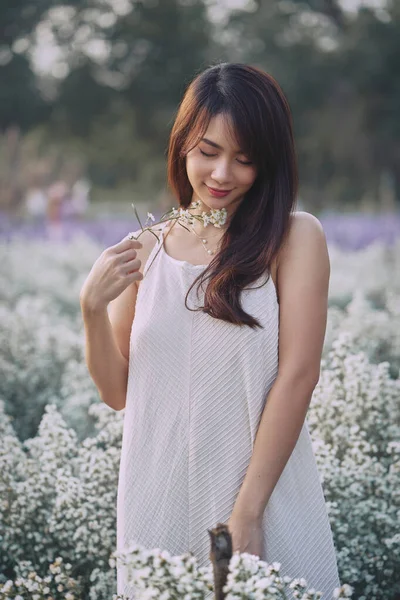 Vacker asiatisk kvinna bär vit klänning promenader i vit cutter blommor trädgård — Stockfoto
