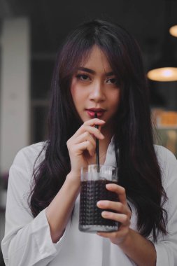Kahve içen Asyalı genç kadın.