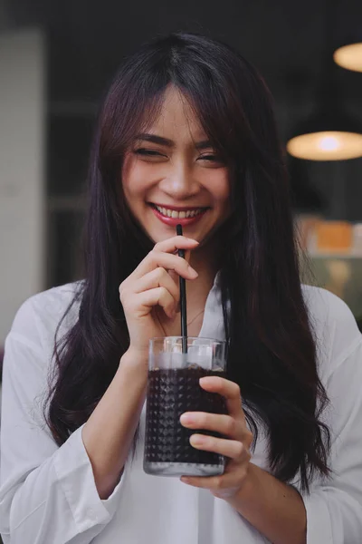 Glad asiatisk ung kvinna dricker kaffe — Stockfoto