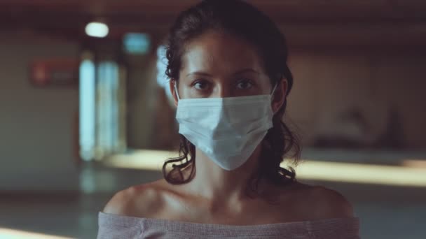 Retrato de una mujer joven con máscara protectora para la cara médica — Vídeos de Stock