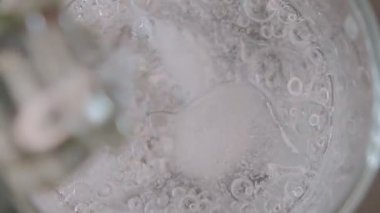 Buzlu bir bardağa soda dökerek, üstten su sıçratarak ve damla damla içerek.