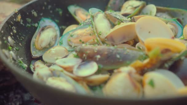 Bir şef plajdaki bir ateşin üzerinde taze midye pişirir. Yavaş çekim yemek videosu. İtalyan makarnası ve midye pişirme süreci — Stok video