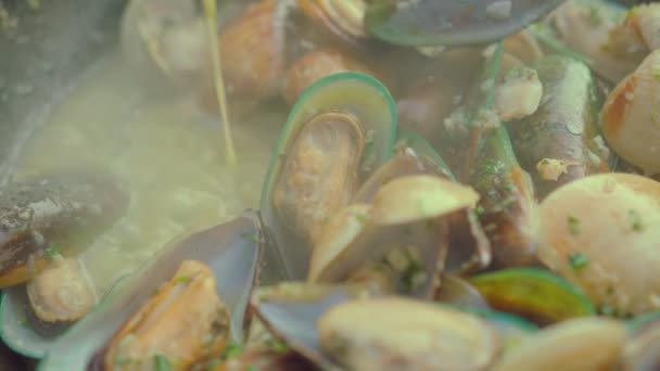 Un chef cocina mejillones frescos en una sartén sobre un fuego en la playa. Vídeo de comida en cámara lenta. Proceso de cocción de pasta italiana con mejillones — Vídeos de Stock