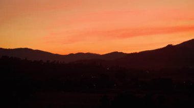 bulutlu turuncu gökyüzü ve dağ silueti