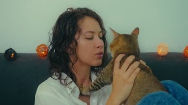 Kanepede kedisiyle dinlenen bir kadın.