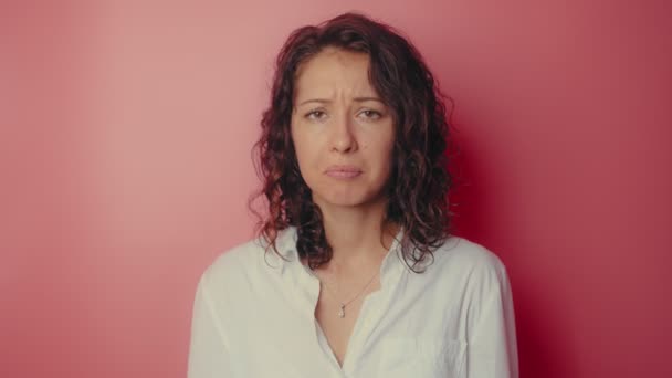 Young attractive girl desperately crying on a pink wall background — Stock Video