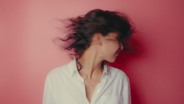 Jonge vrouw schudden haar hoofd geïsoleerd over roze achtergrond — Stockvideo