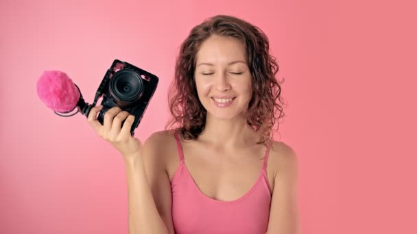 Porträtt av en ung vacker kvinna med videokamera — Stockvideo
