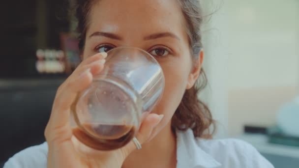 Porträt einer jungen Frau, die heißen Kaffee trinkt, lächelnd in die Kamera im Café-Restaurant blickt — Stockvideo