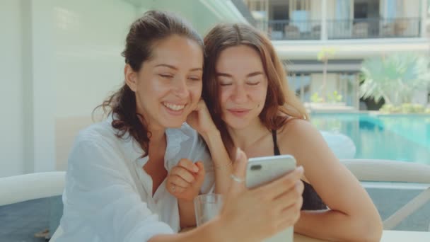 Due giovani donne attraenti che bevono caffè in un ristorante e guardano il telefono — Video Stock