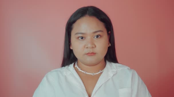 Asiatisk plus storlek kvinna i vit skjorta poserar isolerad på rosa bakgrund. Kroppsligt positivt begrepp — Stockvideo