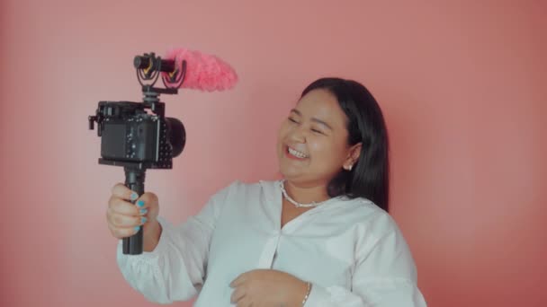 Mulher jovem vlogger gravação transmissão em câmera lenta em um fundo rosa — Vídeo de Stock