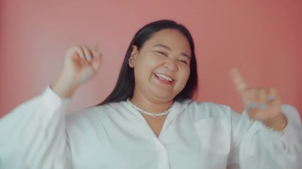 Asiática mujer de talla grande en camisa blanca posando aislada sobre fondo rosa. Concepto positivo corporal — Vídeos de Stock
