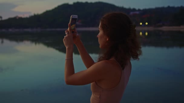 Femme Touriste Prendre des Photos avec Téléphone Portable Caméra de coucher de soleil incroyable aux manteaux — Video
