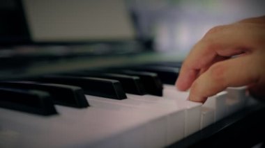 Bir adam klavye enstrümanında müzik çalar. Müzisyen evin terasından esinlenir.