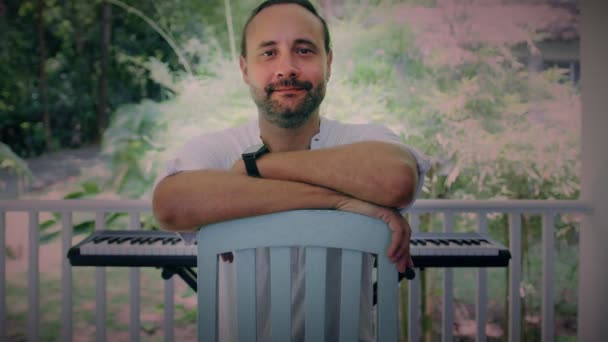 Portrait d'un musicien masculin inspiré sur la terrasse d'une maison. — Video