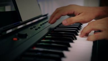 Bir adam klavye enstrümanında müzik çalar. Müzisyen evin terasından esinlenir.