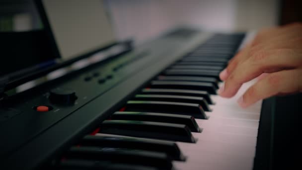 Um homem toca música num instrumento de teclado. O músico é inspirado no terraço da casa — Vídeo de Stock