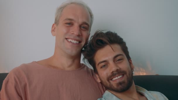 A European gay couple spending time at home. They lie on the couch and use their laptop — Stock Video