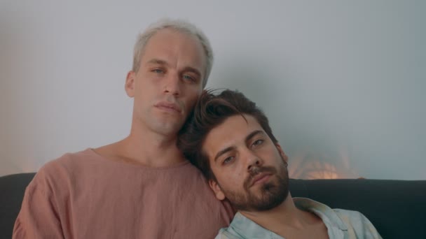 Pasangan gay Eropa menghabiskan waktu di rumah. Mereka berbaring di sofa dan menggunakan laptop mereka — Stok Video